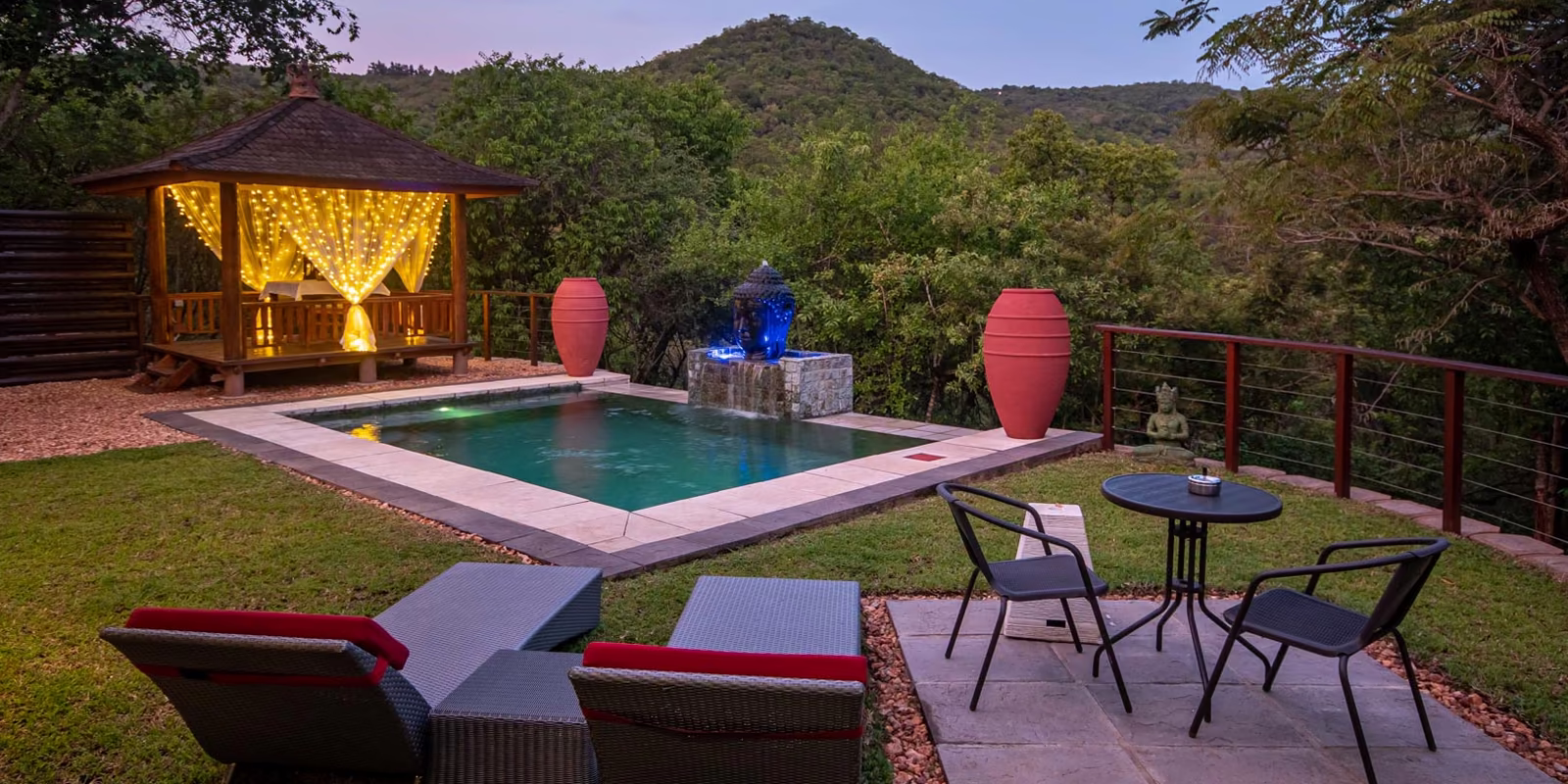 Loungers and the gazebo beside a private pool at dusk