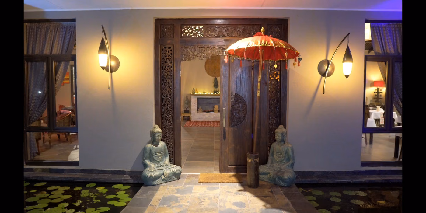 The lantern-lit entrance and gardens at The Zarafa after dark