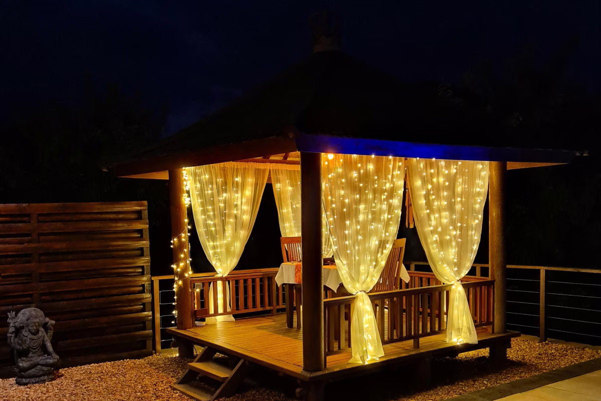 The private dining gazebo at night, curtained in fairy lights