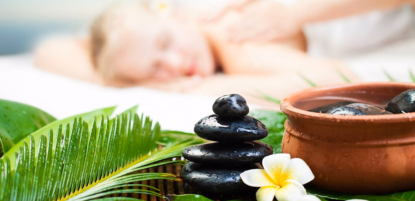 A massage in progress, with hot stones and frangipani